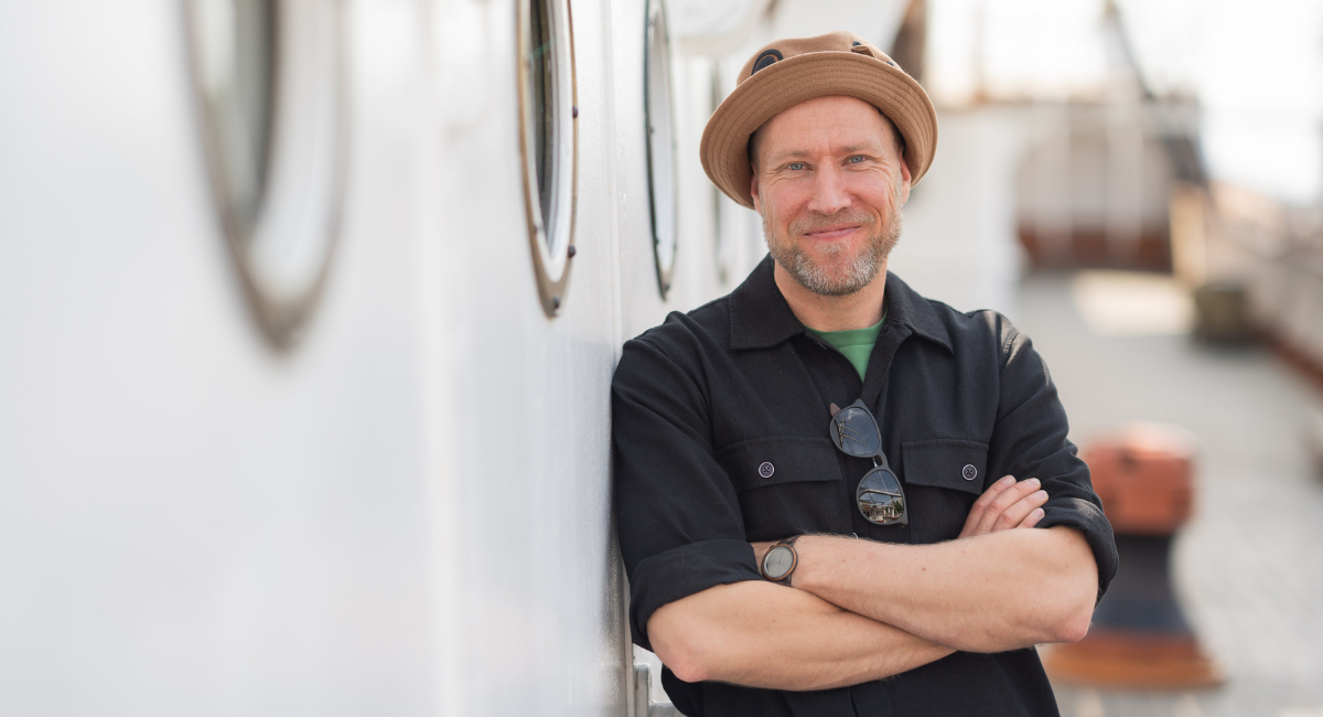 Henkilö nojailemassa seinään museolaiva Suomen Joutsenen kannella.